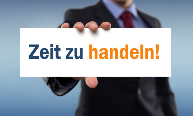 Mann im Anzug hält ein Schild mit der Aufschrift „Zeit zu handeln!“