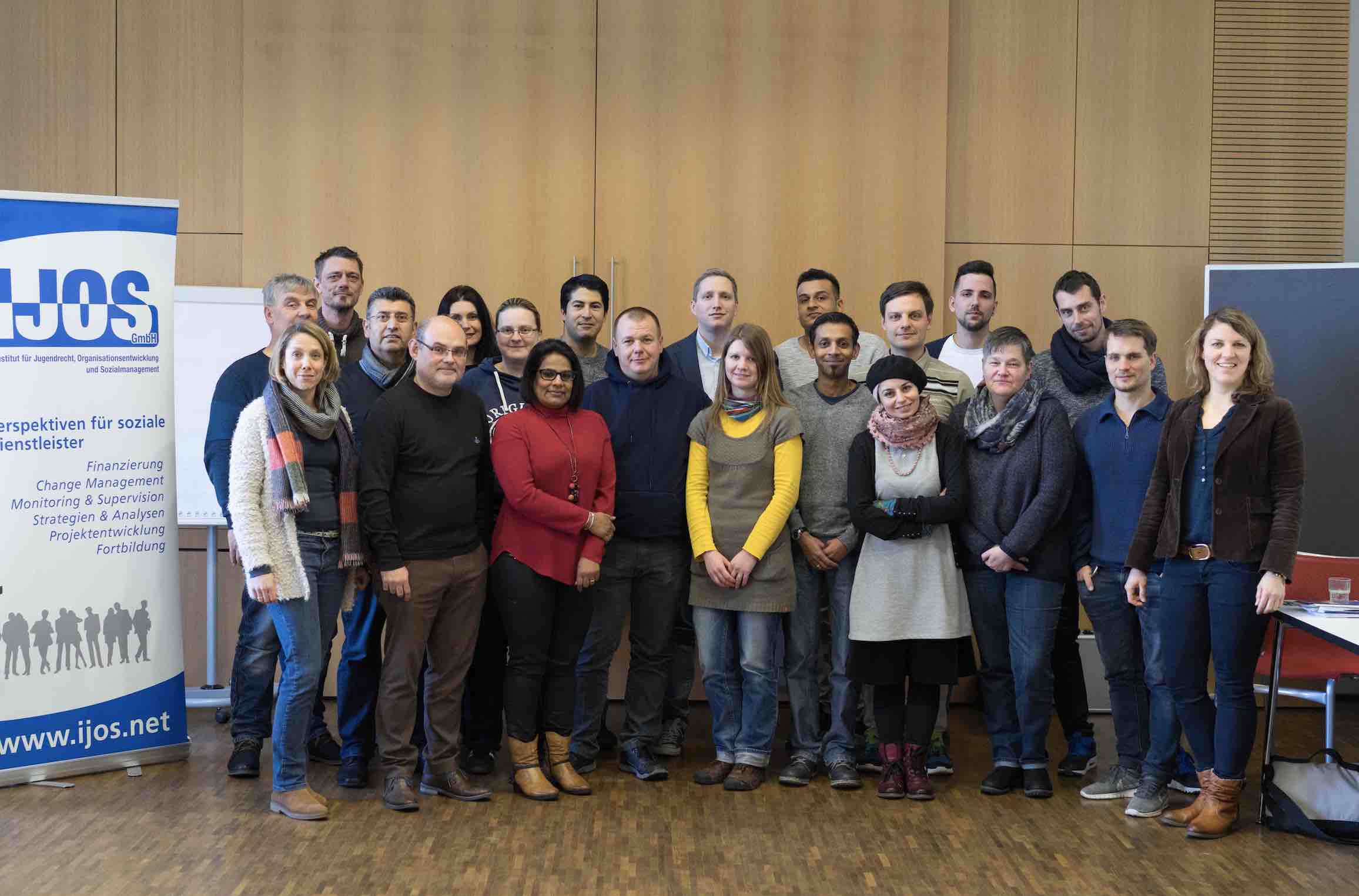 Gruppenfoto des IJOS-Teams vor Aufstellern mit dem IJOS-Logo
