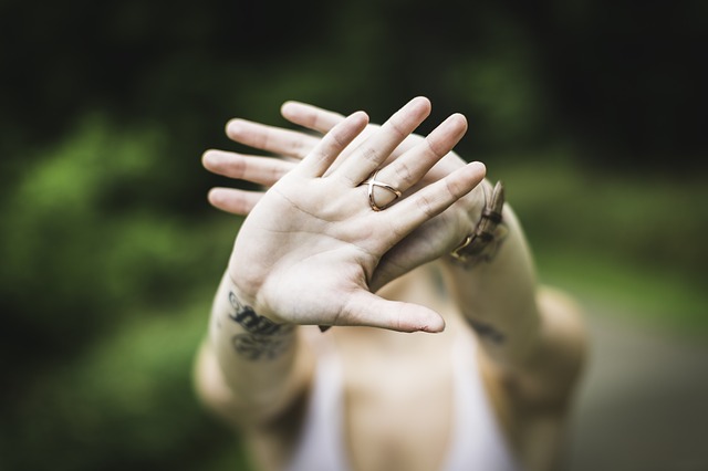Hand streckt sich abwehrend in die Kamera