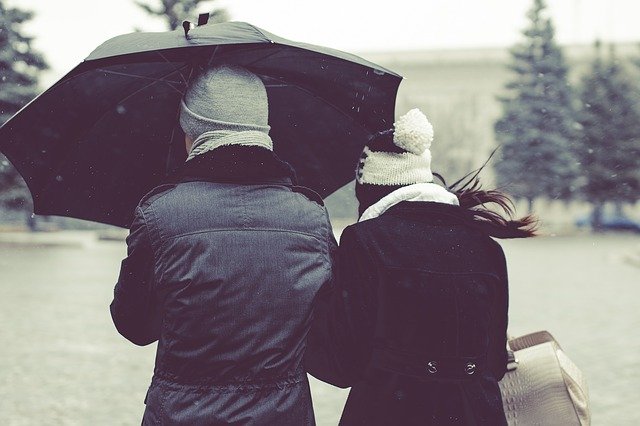 Zwei Menschen mit Regenschirm im Schneetreiben