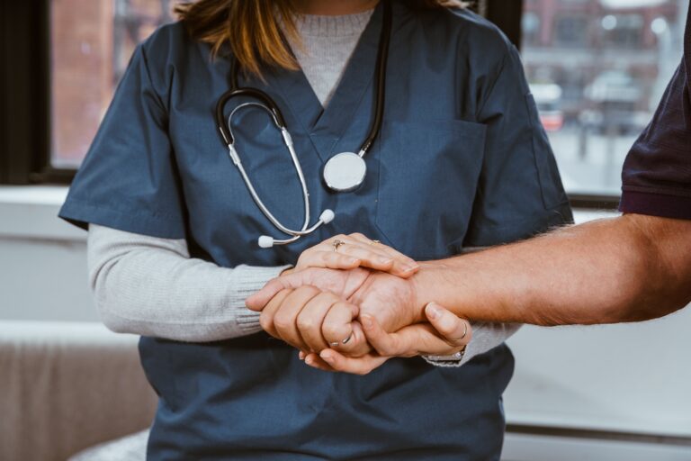 Pflegekraft hält die Hand einer Patientin