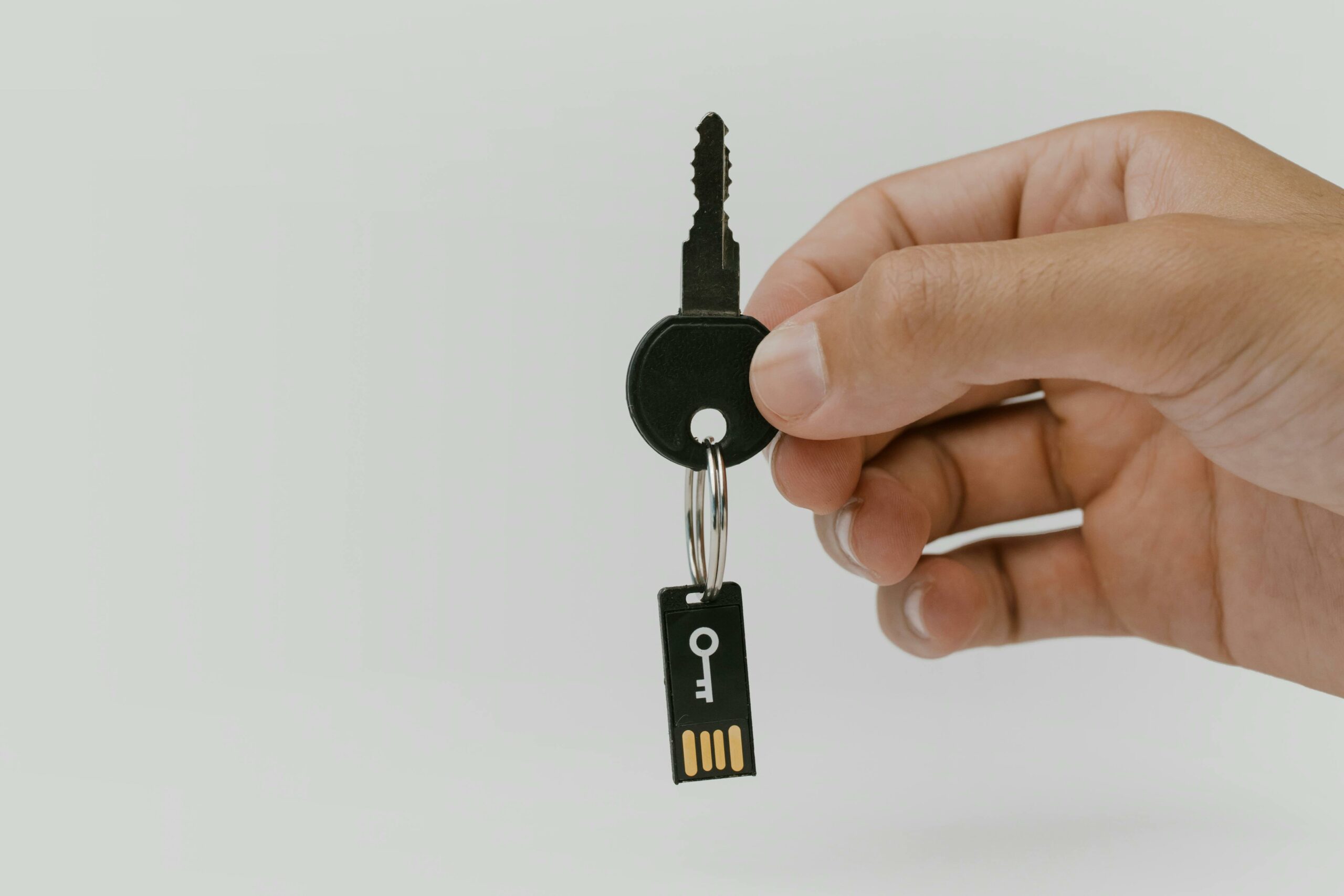 Hand hält einen USB-Stick in Form eines Schlüssels